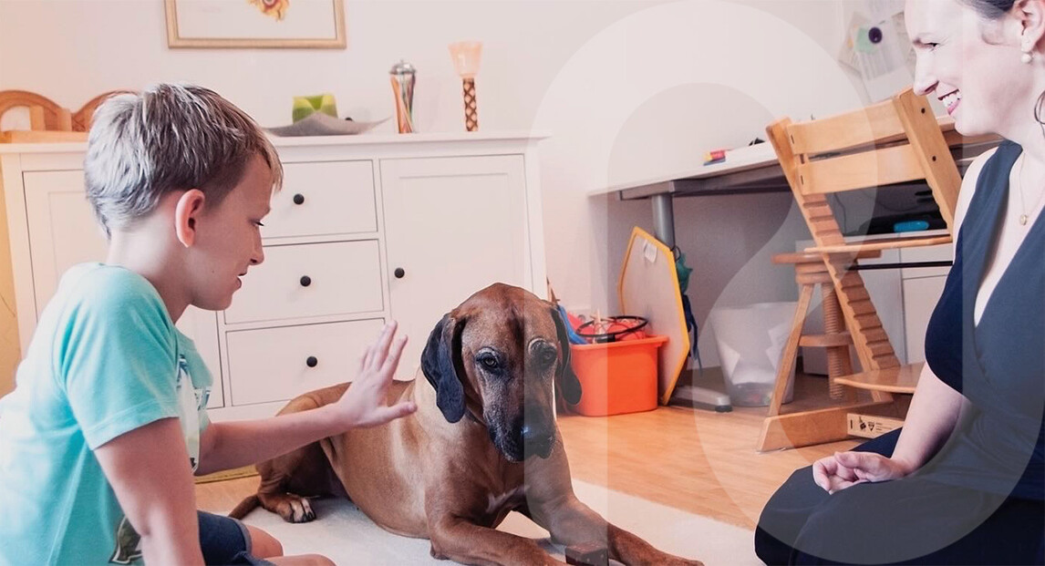 Junge mit Hund im Therapieraum – einfühlsame Atmosphäre in der logopädischen Praxis in Würzburg.